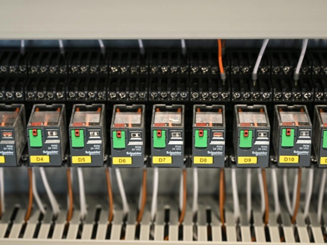 Close-up view of electrical relays in an industrial panel box showcasing circuit components.