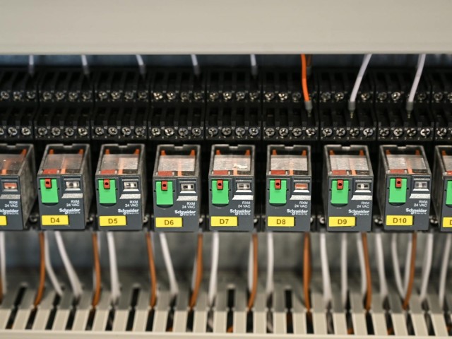 Photo by Vladimir Srajber Close-up view of electrical relays in an industrial panel box showcasing circuit components.